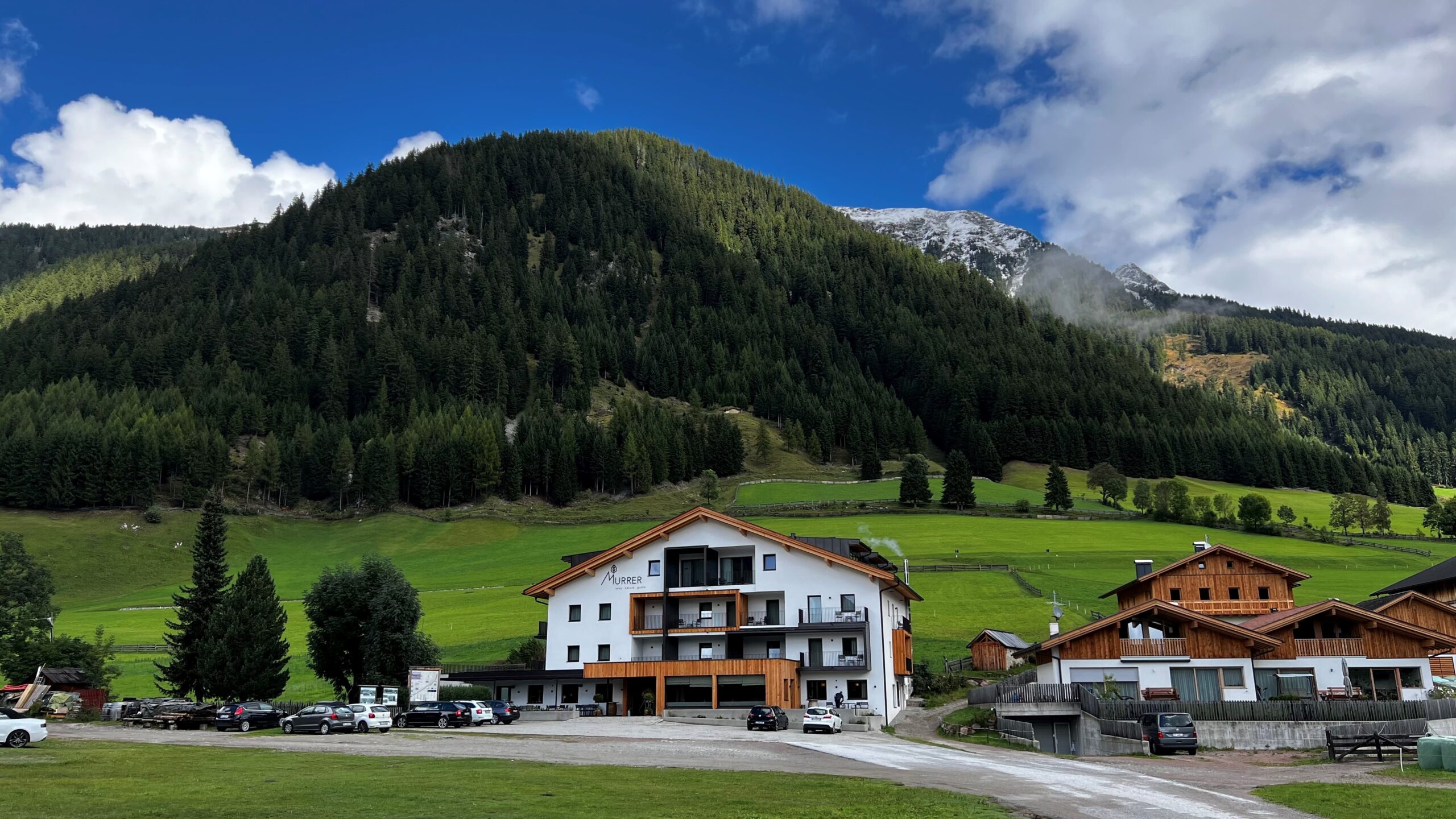 A picture of a guest house in front of the mountains