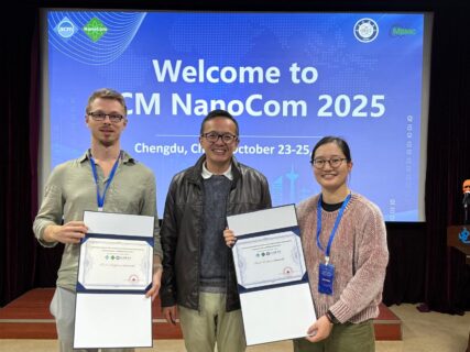 Bastian (male), Kaikai (female) after receiving their awards with a male representative of the NanoCom Committee