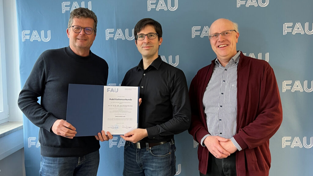 Prof. Marc stamminger (Dean of the Engineering Faculty, male) handing over a habilitation certificate to Prof. Dr. habil Jens Kirchner (male) and Prof. Georg Fischer (male) the mentor of Jens Kirchner