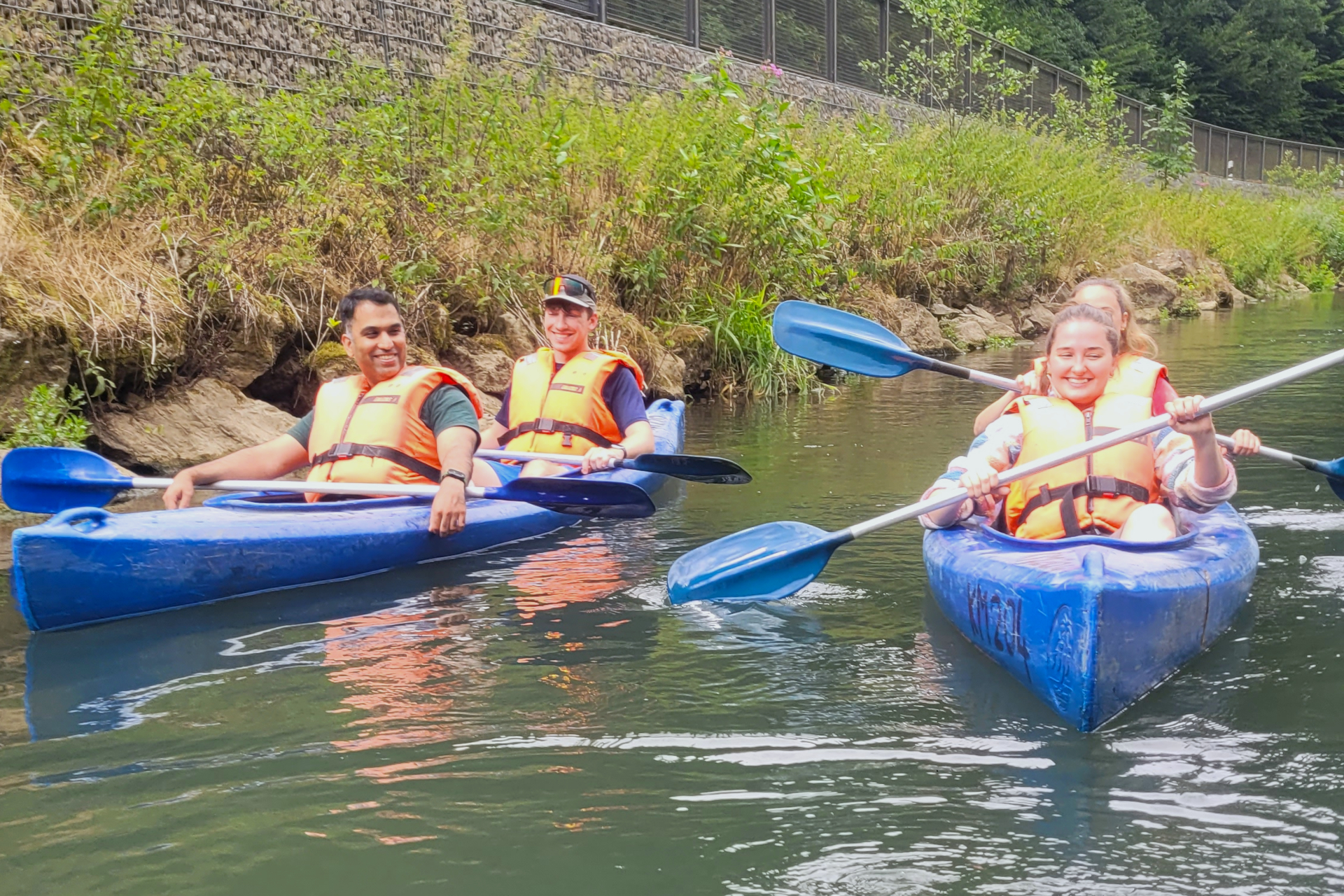 Two kayaks with two males and two females on board on a river